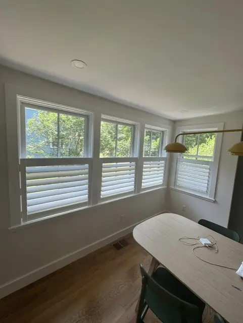 White café shutters on a row of windows in a breakfast nook